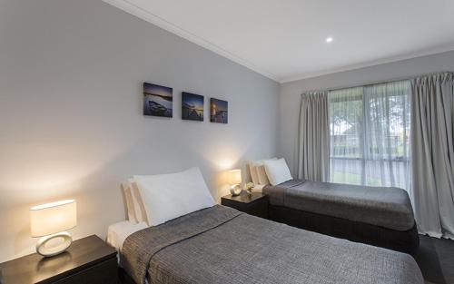 1 dormitorio con 2 camas y ventana en Best Western Colonial Village Motel, en Warrnambool