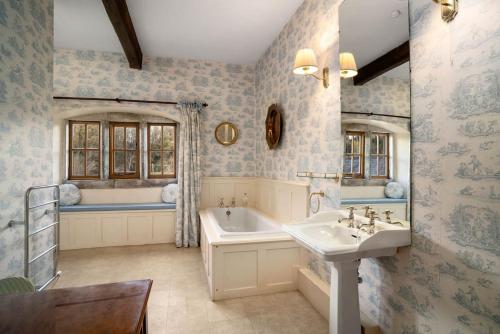 a bathroom with a tub and a sink and a bath tub at Large Country Farmhouse in Waddington