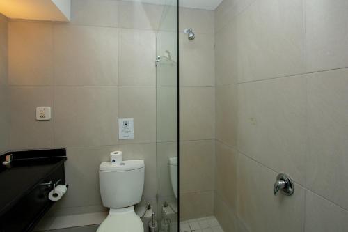 a bathroom with a toilet and a glass shower at Ocean Breeze Hotel in Strand