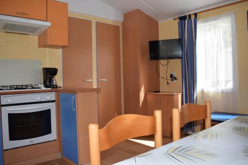 une cuisine et une salle à manger avec une table et des chaises dans l'établissement Camping du Creulet, à Crouay