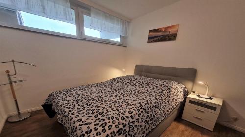 Un dormitorio con una cama en blanco y negro y una ventana en Bonna's Ostsee Oase - Haus Baltic - Whg 180 - Inkl gratis WLAN und Saisonstrandkorb, en Grömitz