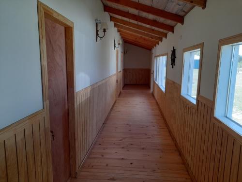 un pasillo en una casa con suelo y ventanas de madera en Portal de la Patagonia Austral, en Puerto Montt
