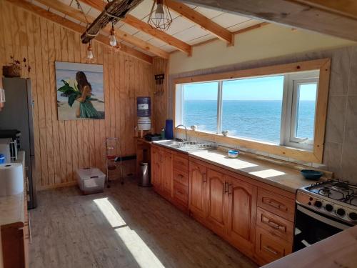 a kitchen with a window and a view of the ocean at Portal de la Patagonia Austral in Puerto Montt