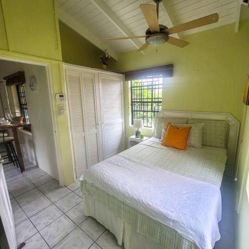 een slaapkamer met een bed met een oranje kussen erop bij Petti Rosa Villa in Gros Islet