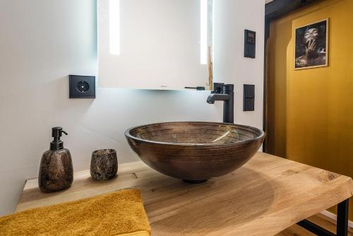 a bathroom with a wooden bowl sink on a wooden table at Goldliebe in Konstanz