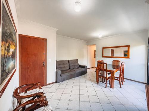 a living room with a couch and a table and chairs at Dois quartos com ar a 190 m de praia Paradisíaca in Guarapari