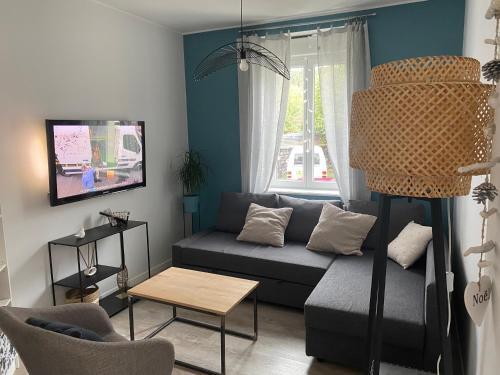 uma sala de estar com um sofá e uma mesa em Maison de ville em Bort-les-Orgues