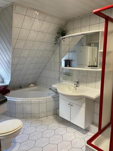 uma casa de banho com uma banheira, um lavatório e um WC. em Mecklenburg Vorpommern em Neukalen