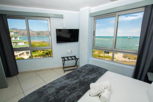 a bedroom with a bed with a view of the ocean at Ocean Breeze Hotel in Strand