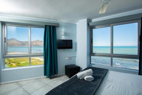 Schlafzimmer mit einem Bett und Meerblick in der Unterkunft Ocean Breeze Hotel in Strand