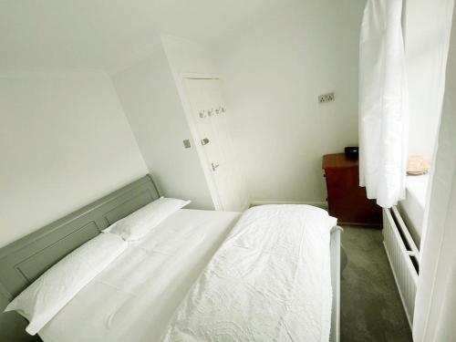 a white bed in a small room with white walls at Khan's Living Lakeside Drive Cyncoed Cardiff in Cardiff