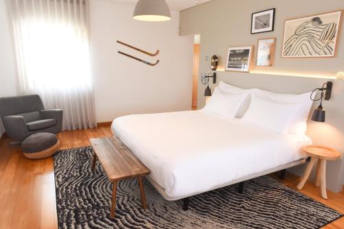 a bedroom with a large white bed and a chair at Villa Tojeira in Sintra