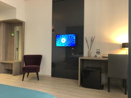 a living room with a tv on a wall at Pensiunea Lido in Piatra Neamţ