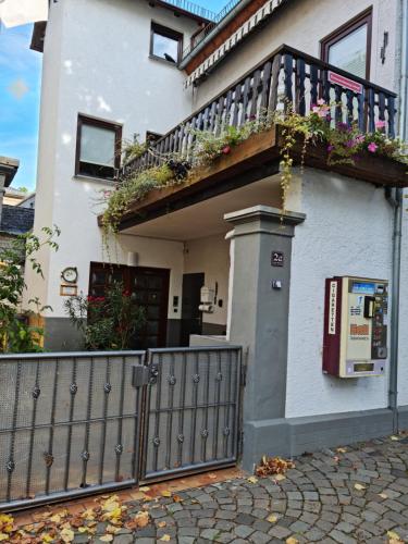 ein weißes Haus mit einem Zaun und einem Balkon in der Unterkunft Haus Grewe in Kaub in Kaub