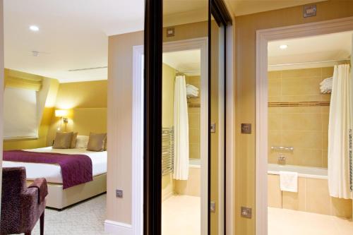 a hotel room with a bed and a bathroom at Cheval Calico House in London