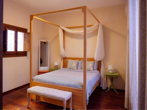 a bedroom with a four poster bed with a canopy at Casa del Armiño Mansión de la Familia de "El Greco" in Toledo