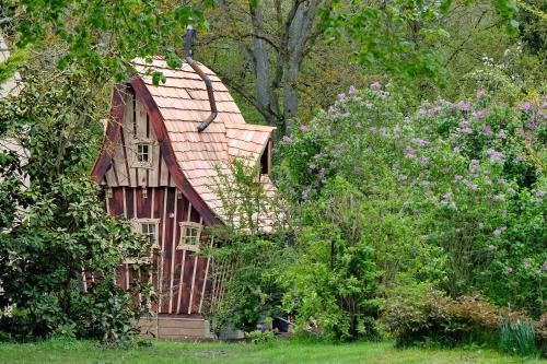 uma pequena casa no meio de algumas árvores em La cabane de Merlin em Les Molières