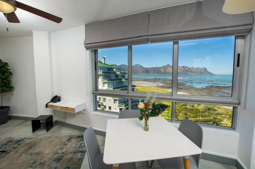 a dining room with a table and a view of the ocean at Ocean Breeze Hotel in Strand