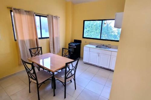 a dining room with a table and chairs and a kitchen at 2 bedroom suite Peguyille 