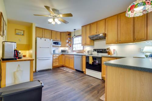 a kitchen with wooden cabinets and a white refrigerator at Athens Vacation Rental - 6 Mi to Ohio University! in Athens