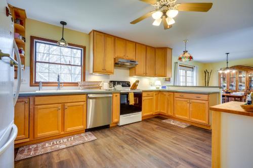 a kitchen with wooden cabinets and a ceiling fan at Athens Vacation Rental - 6 Mi to Ohio University! in Athens
