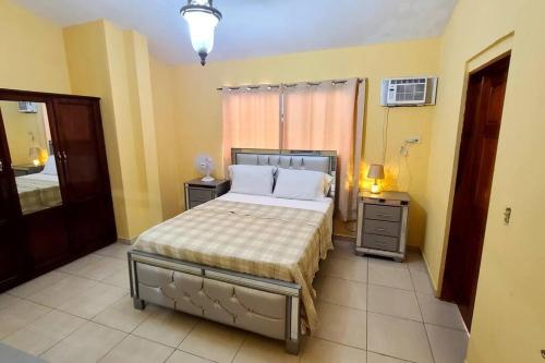 a bedroom with a bed and two tables and a window at 2 bedroom suite Peguyille 