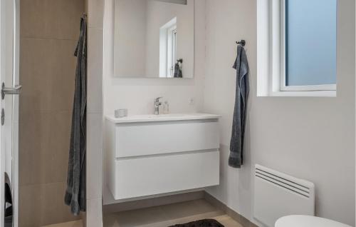 uma casa de banho branca com um lavatório e um espelho em Amazing Home In Stubbekbing With Wifi em Stubbekøbing