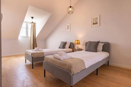 a bedroom with two beds and a table with a lamp at Monteverde VI by Innkeeper in Lisbon