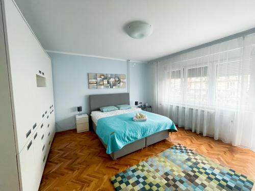 a bedroom with a bed with a blue comforter at Broj jedan Delux in Soko Banja