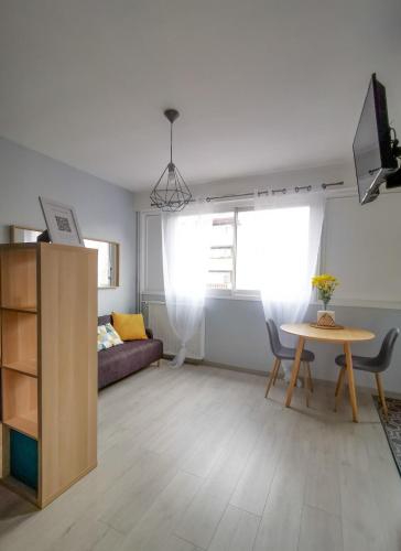 salon z kanapą i stołem w obiekcie Cosy 30m in the heart of Villeurbanne w mieście Villeurbanne