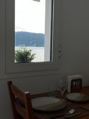 a table with a window and a table with glasses at Plateia sea view loft in Samos