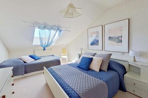 2 camas en un dormitorio con azul y blanco en Les Jardins de la Muse, piscine couverte, spa et fitness en Basse-Goulaine
