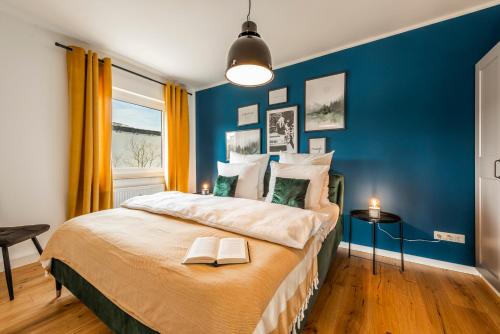 ein blaues Schlafzimmer mit einem Bett mit zwei Büchern darauf in der Unterkunft Klassen Stay - Exklusives Apartment - Zentral und 4km zur Messe -Kingsizebett in Essen