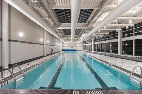 a large indoor swimming pool with blue water at Condo in Downtown Vancouver - Near Rogers Arena in Vancouver