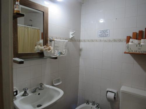 y baño con lavabo, espejo y aseo. en Yporá Lodge en Colonia Carlos Pellegrini