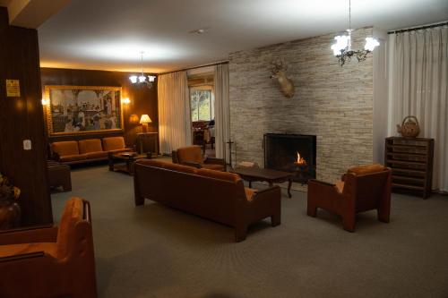 a living room with couches and a fireplace at Hotel Ascona in Campos do Jordão