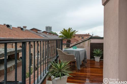 a balcony with a table and chairs on a building at MURANO Suites BOUTIQUE Apartments adults only in Murano