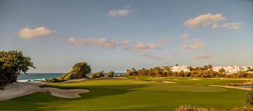 una vista de un campo de golf con el océano en el fondo en Aurora Anguilla Resort & Golf Club en Rendezvous Beach