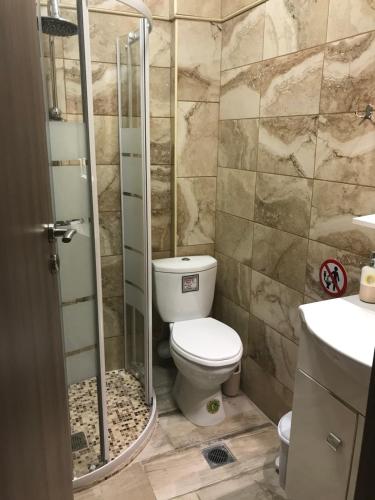 ein Badezimmer mit Toilette und Glasdusche in der Unterkunft Jozy in Peraia