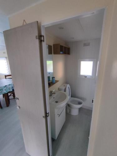 米米藏的住宿－Mobil home 4 couchages，白色的浴室设有卫生间和水槽。