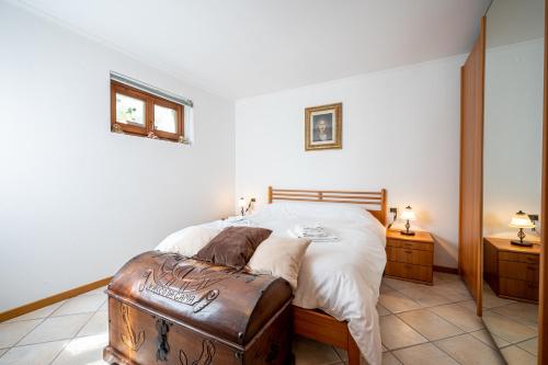 una camera da letto con un letto con ottomana in pelle marrone di Apartment with bicycle storage in Dongo - Larihome A24 a Dongo