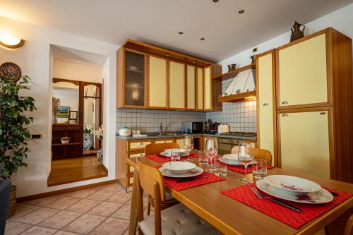 una cucina con tavolo in legno, piatti e bicchieri di Apartment with bicycle storage in Dongo - Larihome A24 a Dongo