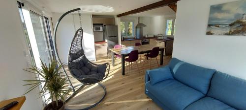 - un salon avec un canapé bleu et une balançoire dans l'établissement Maison de vacances 4 Pers avec jardin privatif à 1km PLAGE Lines et 300m de la mer de Gâvres - AR PIL JADUR, à Plouhinec