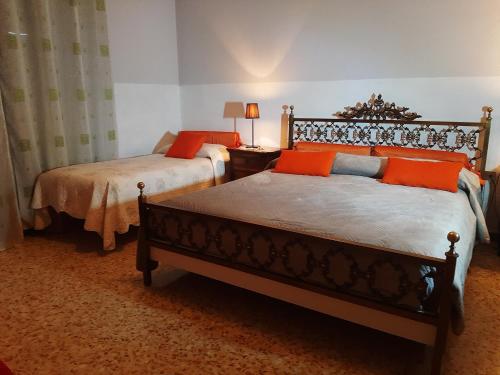1 dormitorio con 2 camas con almohadas de color naranja en Bed and Breakfast Big Brother, en Treviso