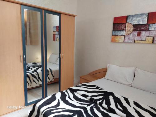 a bedroom with a zebra print bed and a mirror at Appartement entier à une chambre à coucher in Agadir