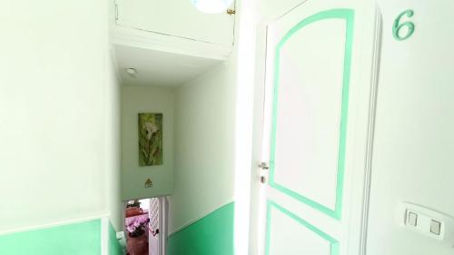 an open door in a room with green and white at Hotel Casa Nicola in Ischia
