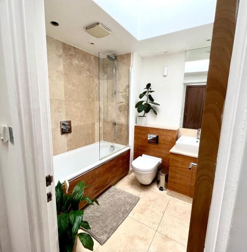 La salle de bains est pourvue d'une baignoire, de toilettes et d'un lavabo. dans l'établissement The Loft Queens Park, à Londres