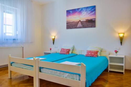Schlafzimmer mit einem Bett mit blauer Tagesdecke in der Unterkunft Holiday House Larma in Senj