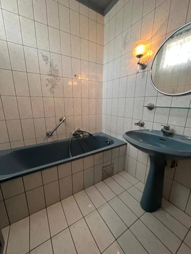 bagno con vasca, lavandino e specchio di Mediterrane Ferien Villa am Neusiedler See a Gols