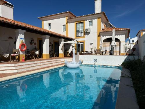 a swimming pool in front of a house at Paradise-AL in Porto Covo